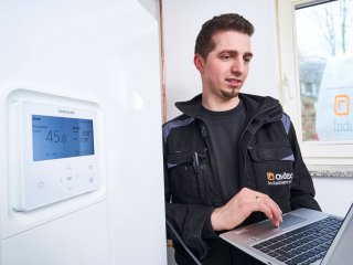 Mitarbeiter überprüft Heizungsdaten am Laptop