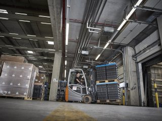 Forklift driver transports pallet with goods